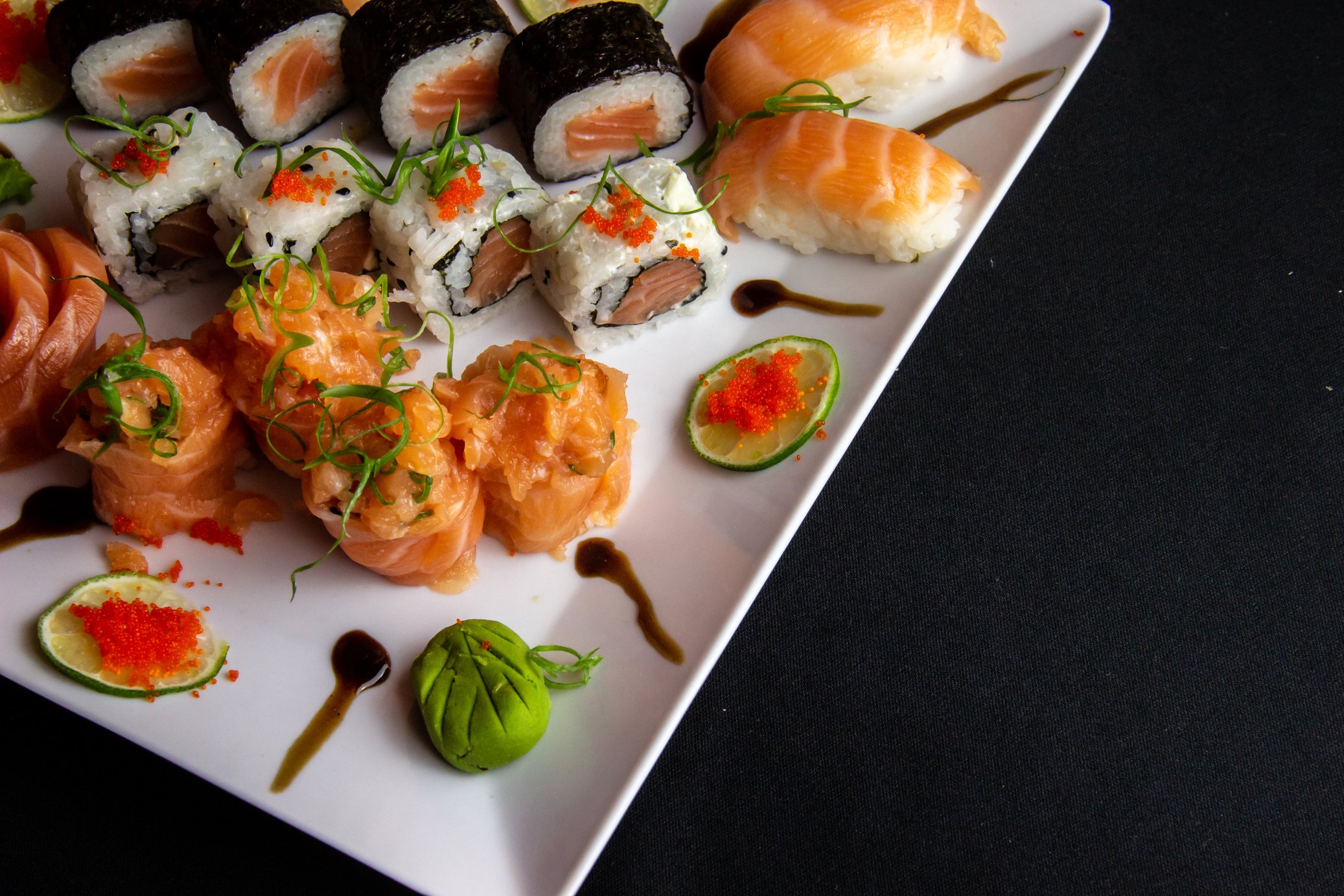 an assortment of sushi on a white plate